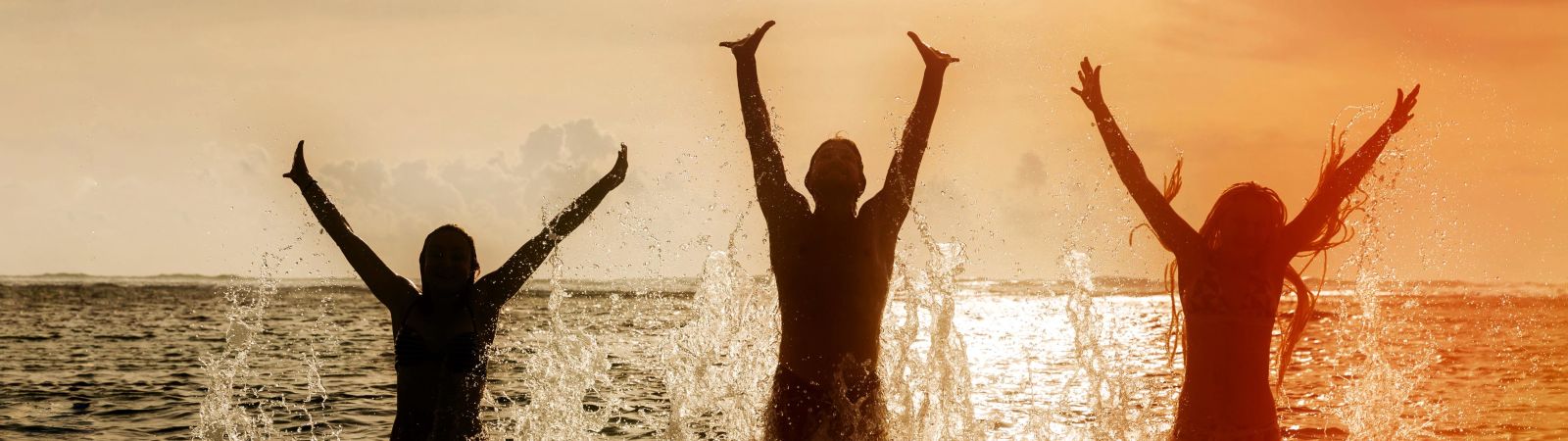 family jumping in the ocean