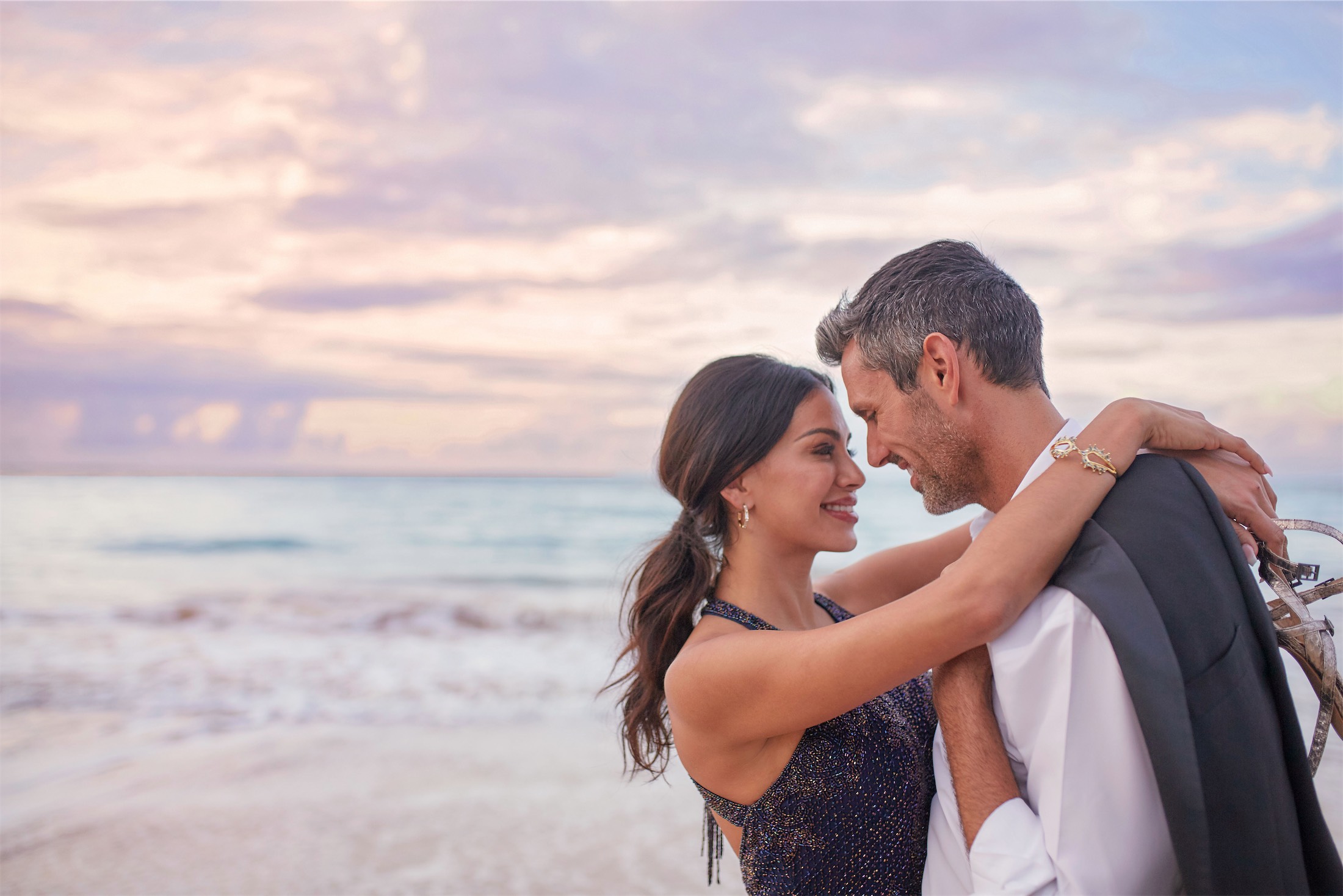 man and woman hugging on the beach