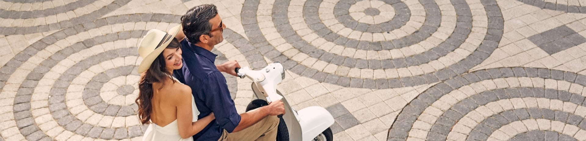 man and woman riding a vespa
