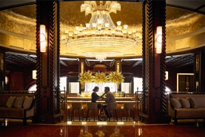 a couple sitting at the chandelier bar