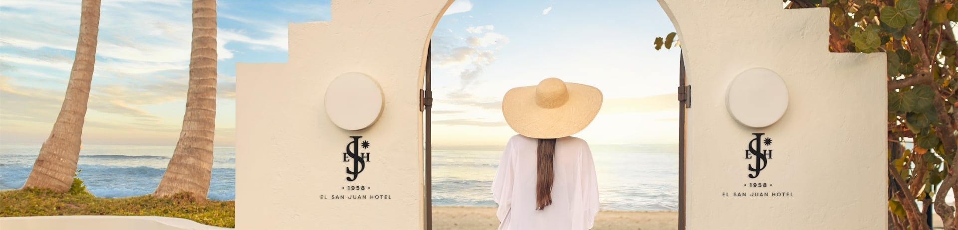 woman walking through an archway to the beach