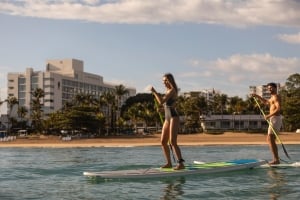couple paddleboarding on the beach