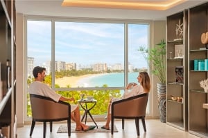 pareja sentada junto a una ventana con vistas al océano