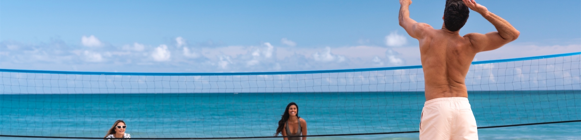 3 people playing beach volleyball