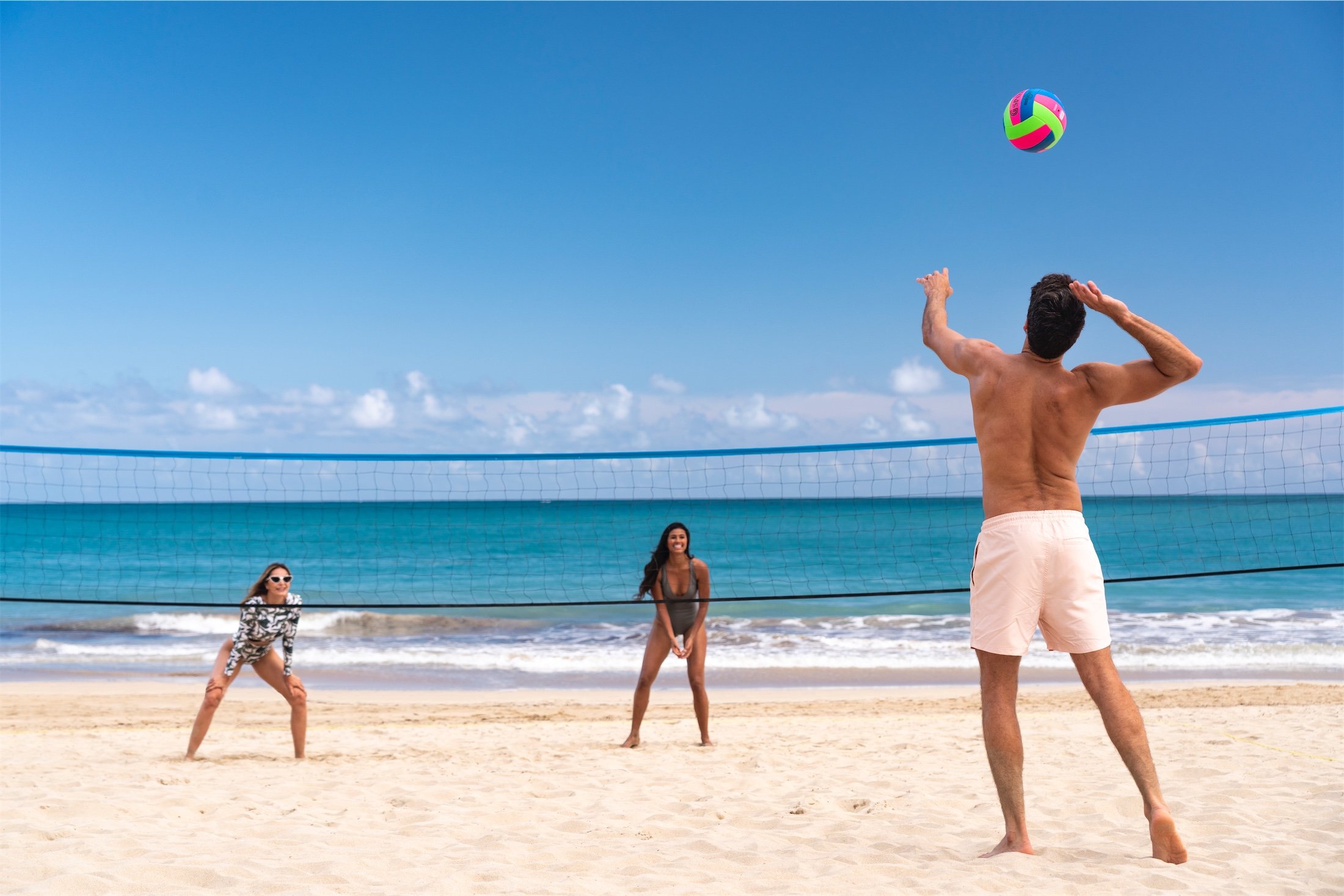 3 people playing beach volleyball