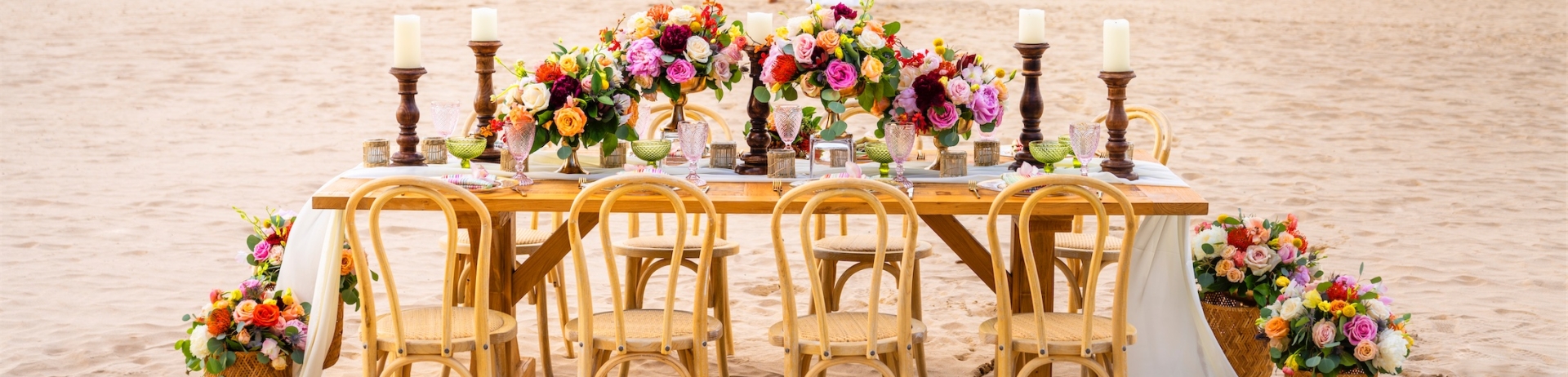 couple walking towards to ocean behind a table set up for a wedding