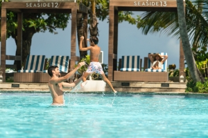 father throwing son in the pool