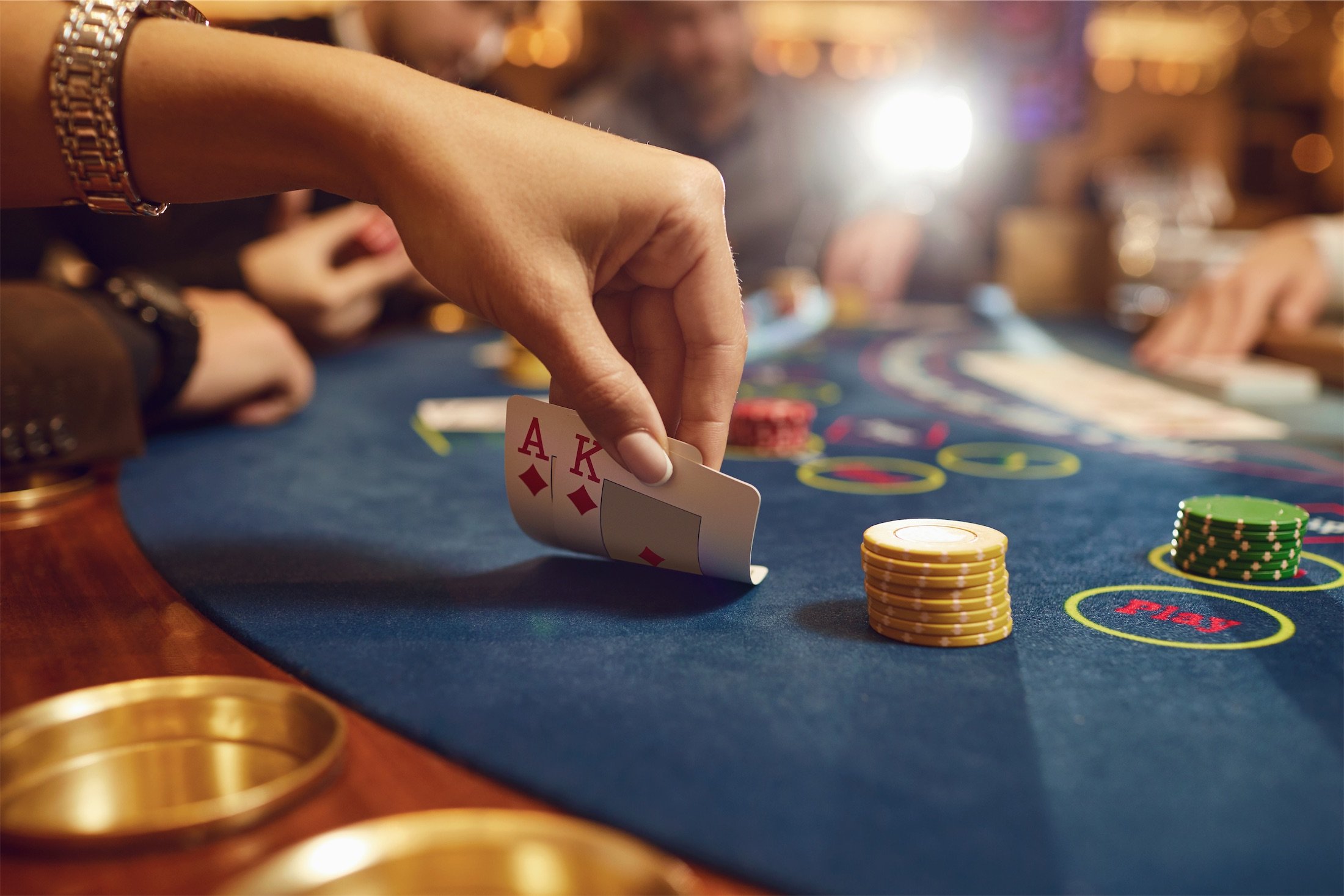 person playing blackjack looking at their cards