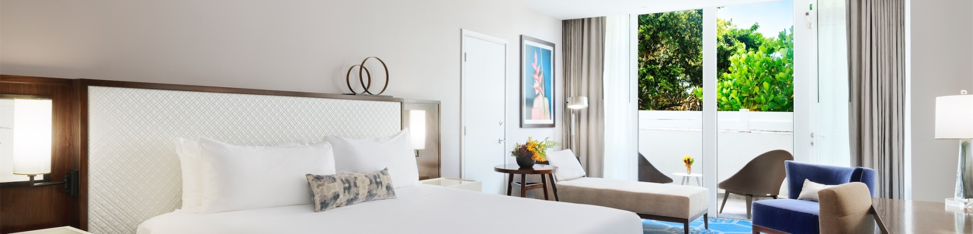 king sized bed in a room with a desk and cushioned seating