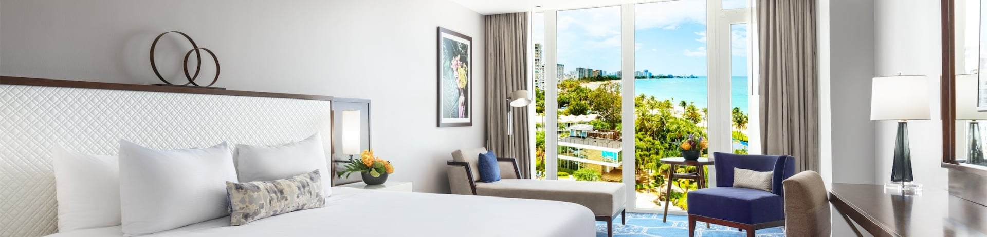 bedroom with king bed and view of pool and gym area