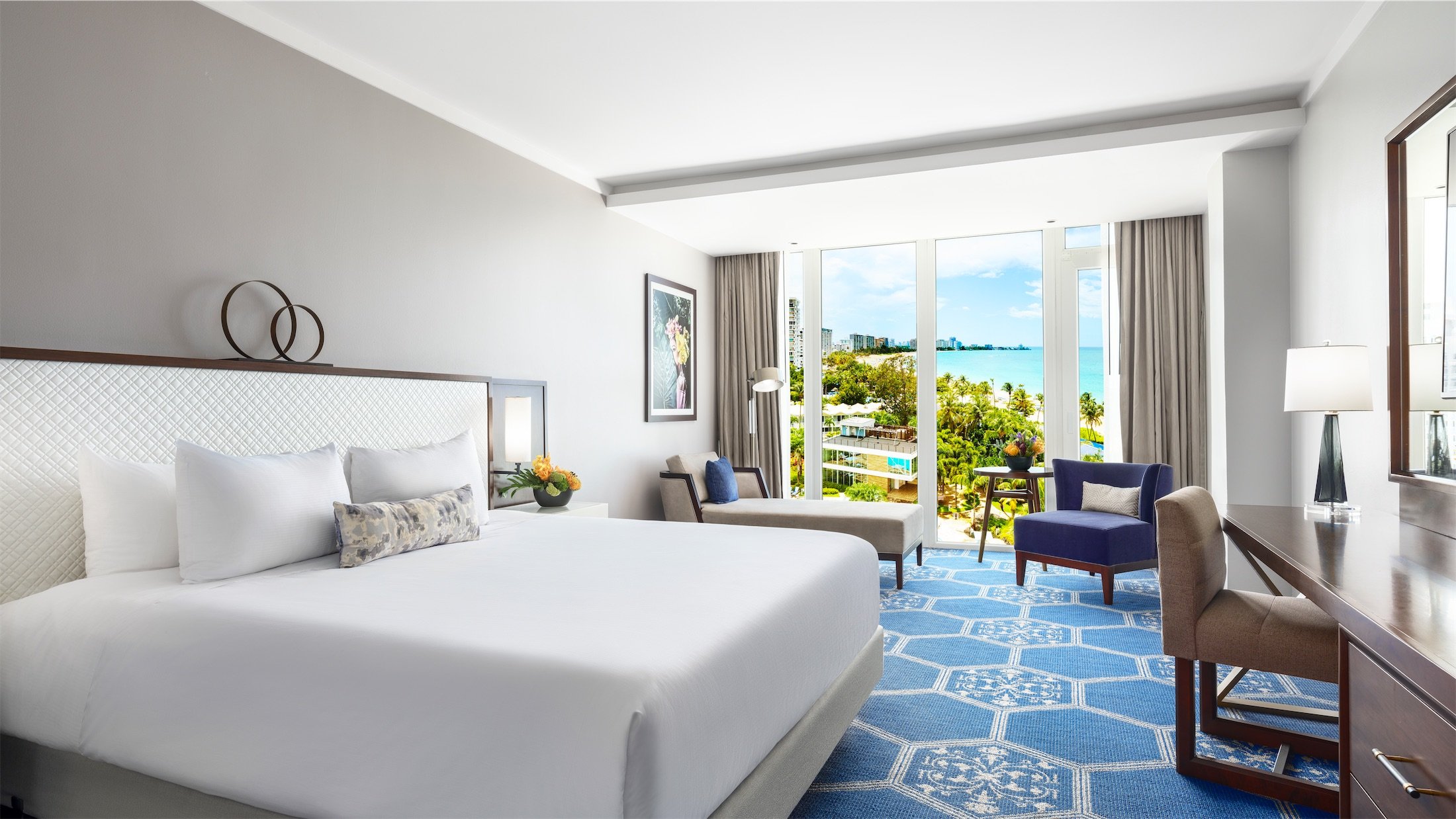 bedroom with king bed and view of pool and gym area