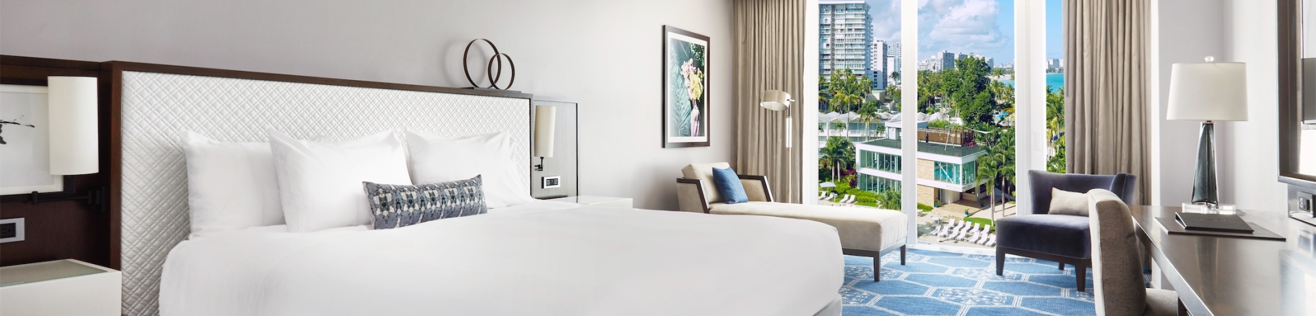 bedroom with king bed and view of pool area and gym