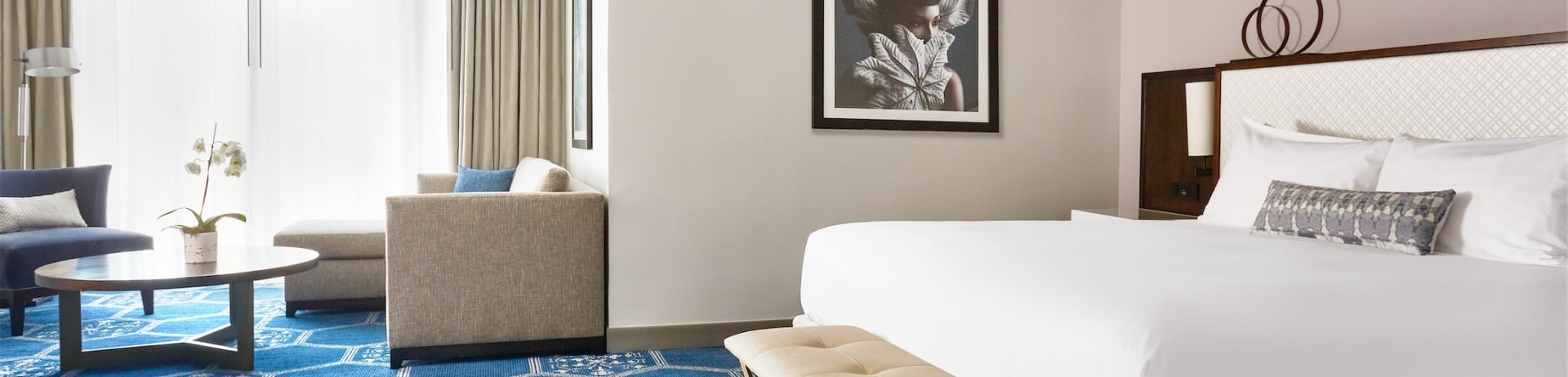 king sized bed in a room with a portrait on the wall