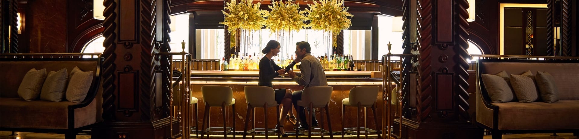 couple sitting together at a bar with a large chandelier
