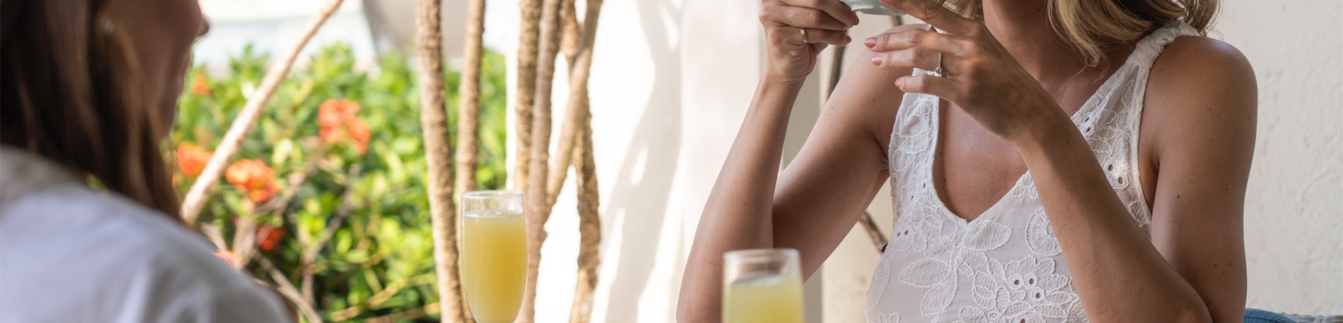 Two women having breakfast with coffee and mimosas