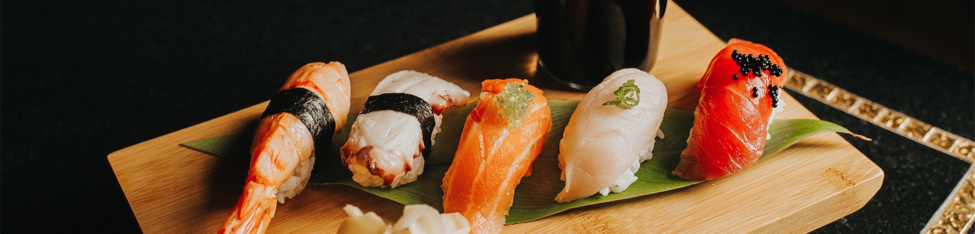 sushi on a board with a bottle of soy sauce