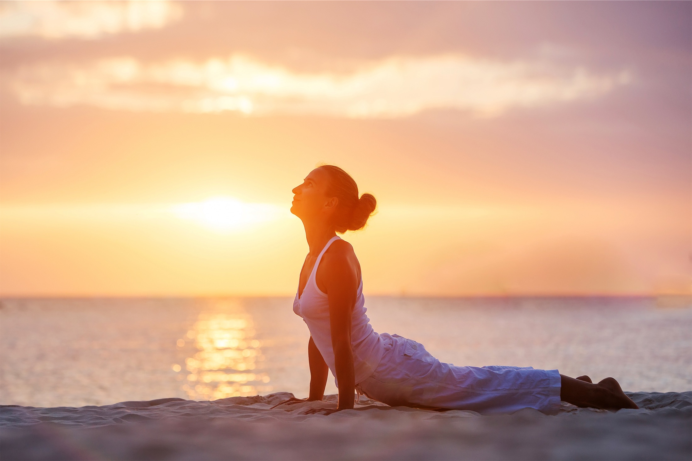 woman doing yoga on the beach