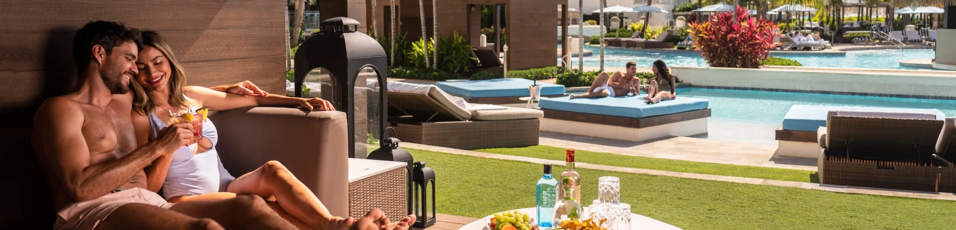 couple sitting on a couch next to the pool