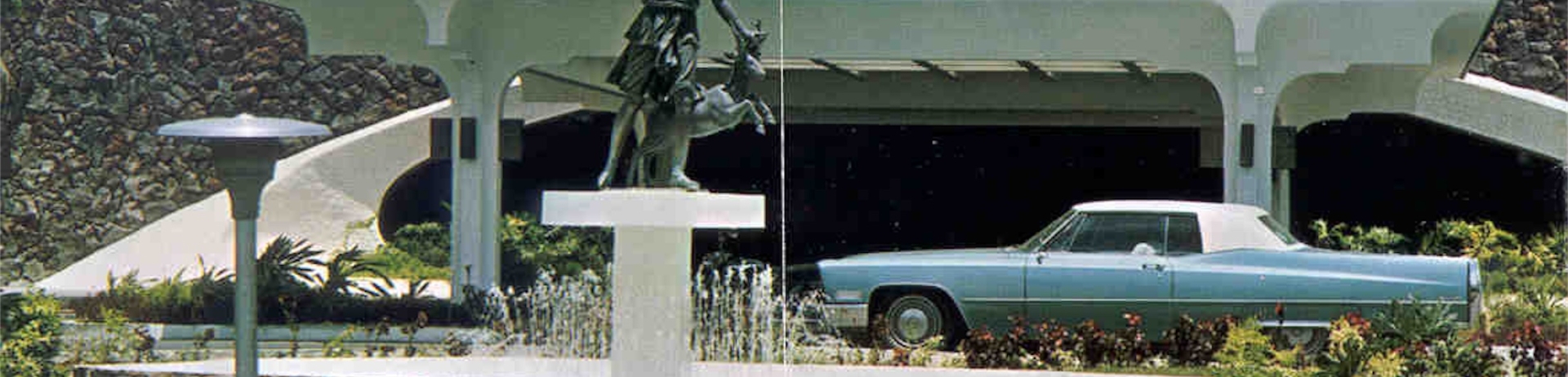 foto histórica de un coche junto a una estatua